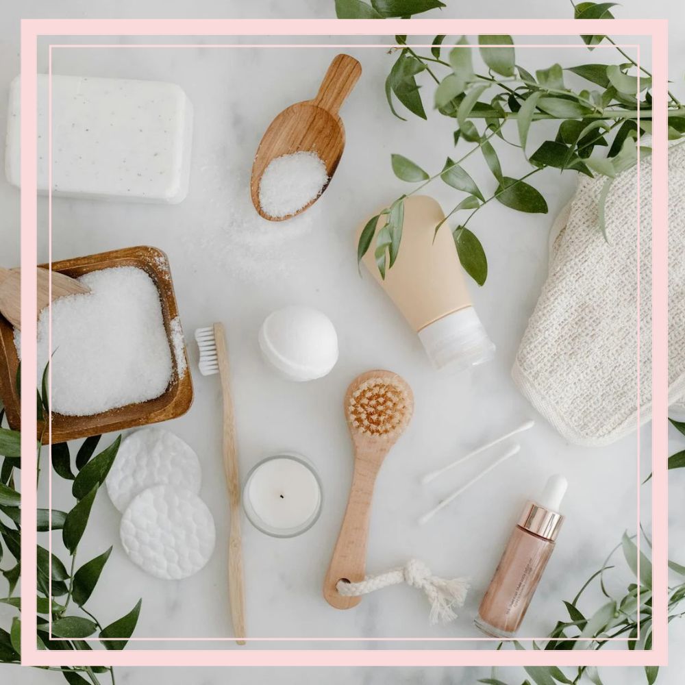 Flat lay of natural skincare tools and beauty products on marble surface